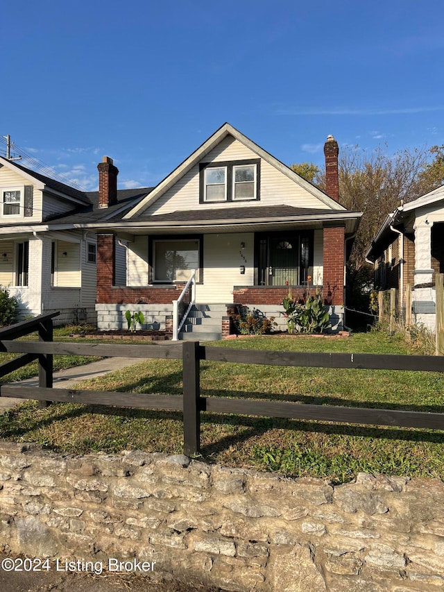 view of front of house featuring covered porch and a front yard