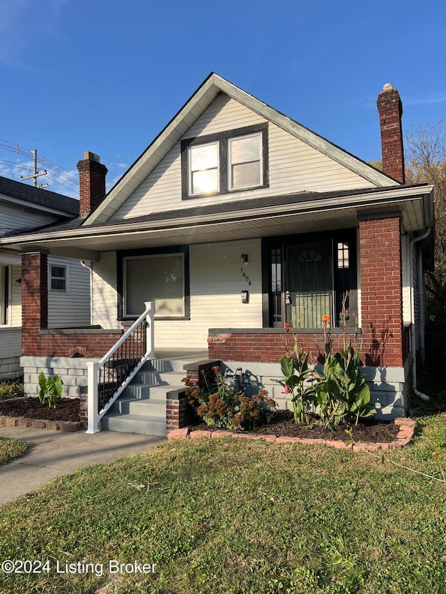 view of front facade with covered porch and a front yard