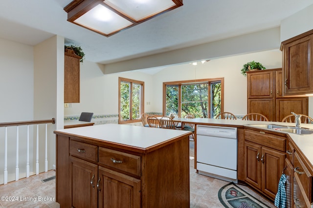 kitchen with a center island, sink, and white dishwasher