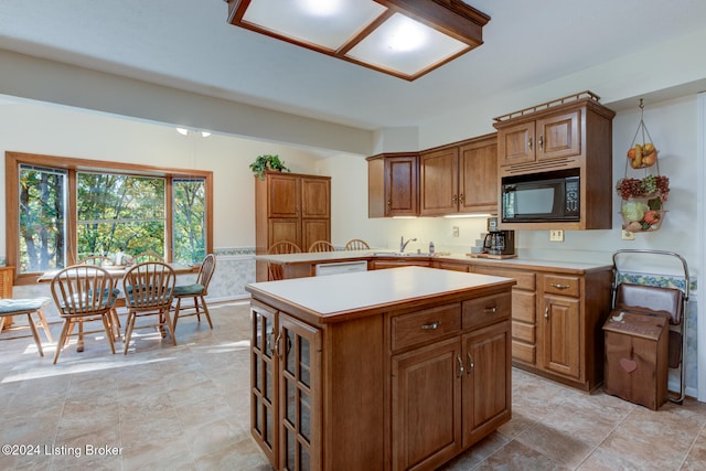 kitchen featuring black microwave, sink, white dishwasher, and a kitchen island