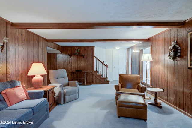 carpeted living room featuring beamed ceiling, wooden walls, and a textured ceiling