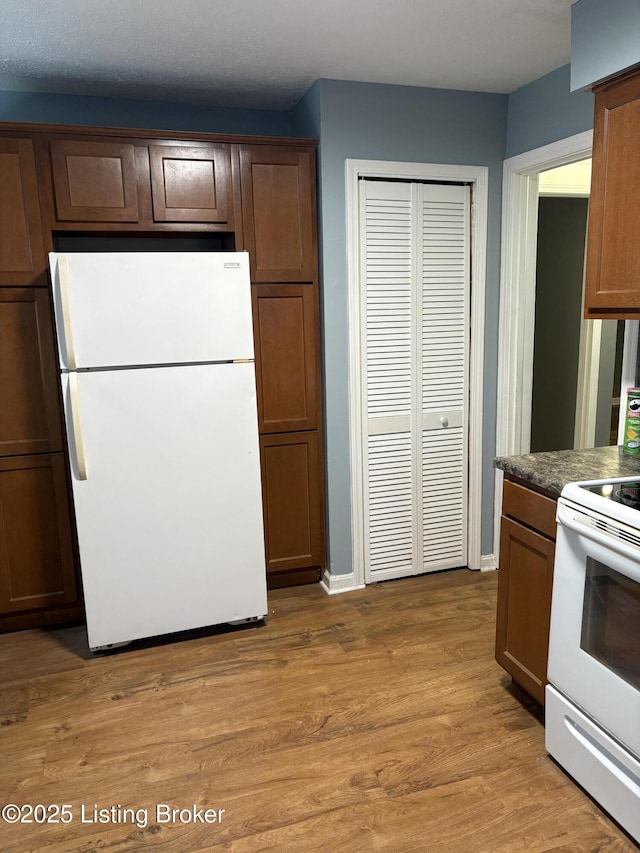 kitchen with white appliances and light hardwood / wood-style floors