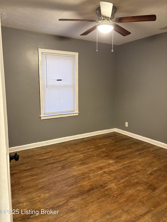 empty room featuring dark wood-type flooring, a textured ceiling, and ceiling fan