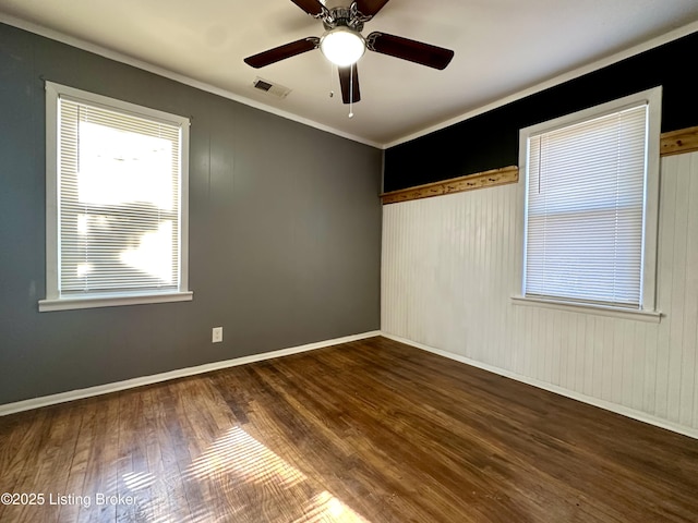 spare room with crown molding, dark hardwood / wood-style floors, and ceiling fan