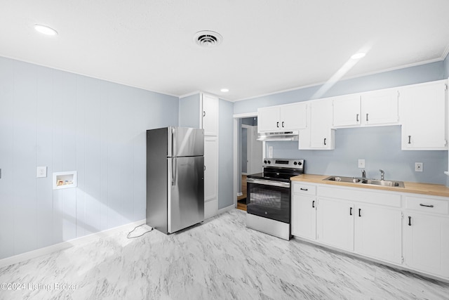 kitchen featuring white cabinets, wood walls, sink, and appliances with stainless steel finishes