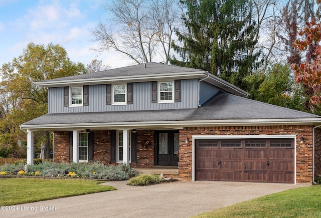 view of front of home featuring covered porch, a front yard, and a garage