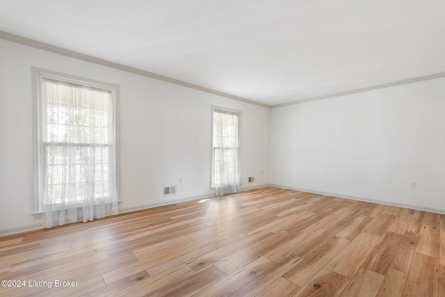 empty room featuring light hardwood / wood-style floors and ornamental molding