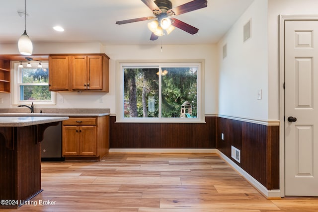 kitchen with sink, dishwasher, light hardwood / wood-style floors, ceiling fan, and decorative light fixtures