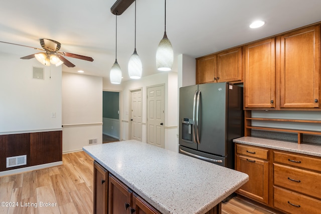 kitchen with a kitchen island, hanging light fixtures, ceiling fan, stainless steel fridge with ice dispenser, and light hardwood / wood-style flooring