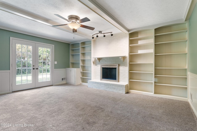 unfurnished living room with french doors, a textured ceiling, track lighting, and carpet floors