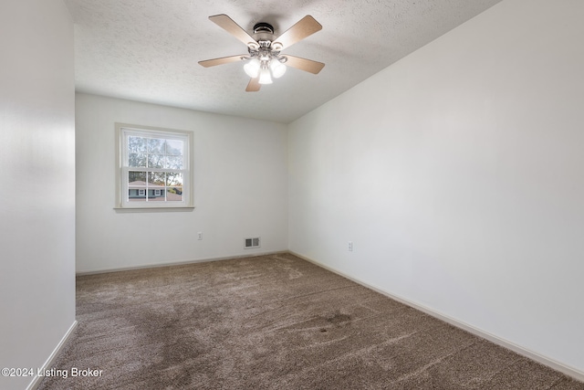 carpeted spare room with a textured ceiling and ceiling fan