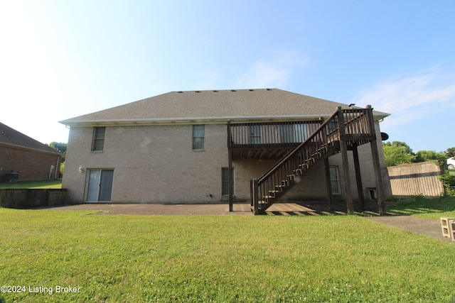 back of property with a wooden deck and a lawn