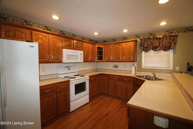 kitchen with kitchen peninsula, tasteful backsplash, dark hardwood / wood-style flooring, sink, and white appliances