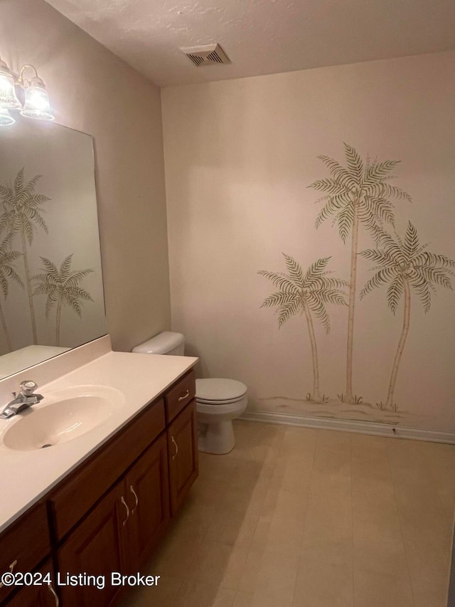 bathroom featuring vanity, toilet, and a textured ceiling