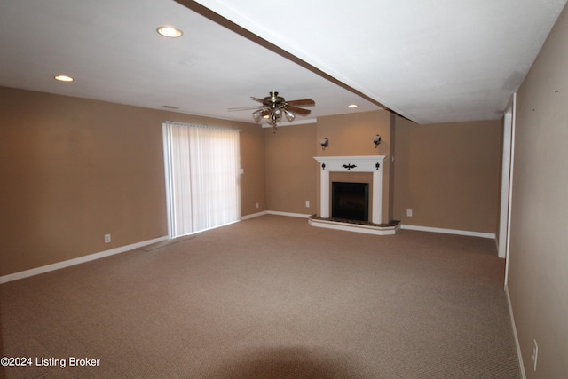 unfurnished living room featuring ceiling fan and carpet floors