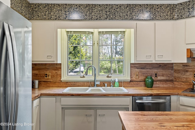 kitchen featuring white cabinetry, sink, backsplash, and stainless steel appliances