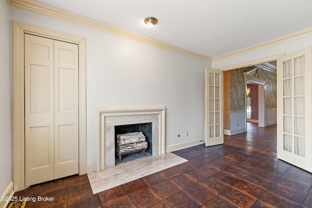 unfurnished living room with a premium fireplace, ornamental molding, and french doors