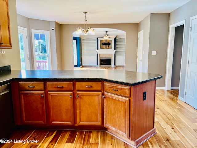 kitchen featuring light hardwood / wood-style flooring, stainless steel dishwasher, hanging light fixtures, and kitchen peninsula