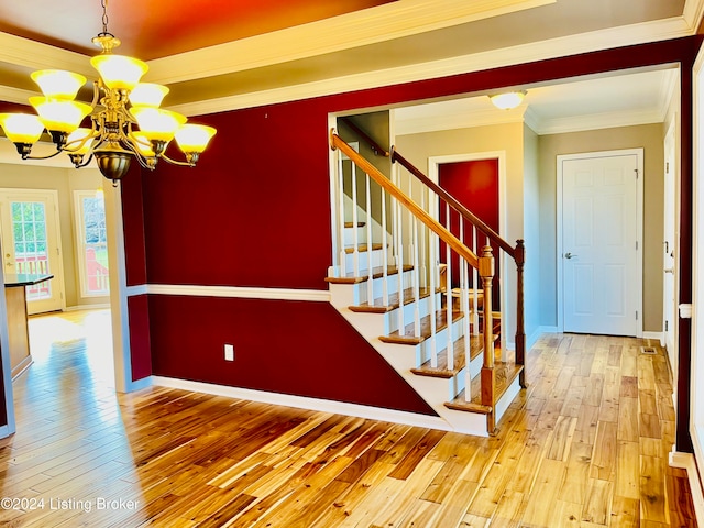 staircase featuring crown molding, wood-type flooring, and an inviting chandelier