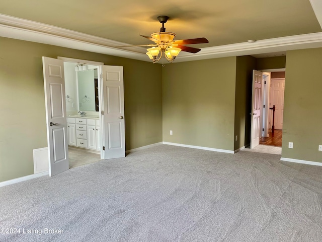 unfurnished bedroom with connected bathroom, light carpet, and ceiling fan