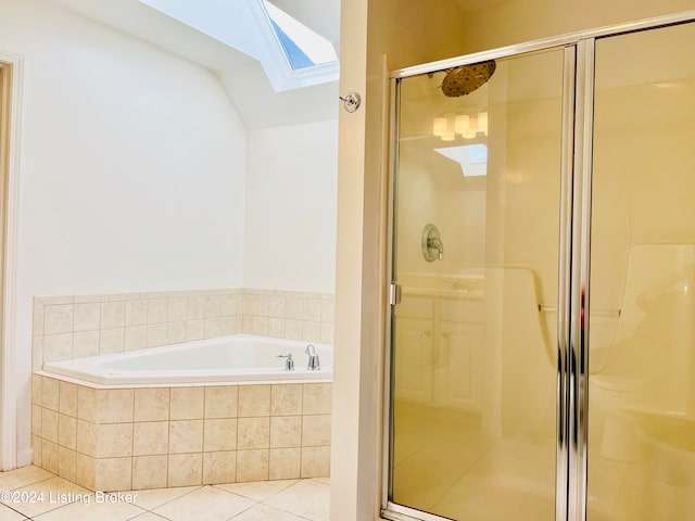 bathroom featuring tile patterned flooring, a skylight, and shower with separate bathtub