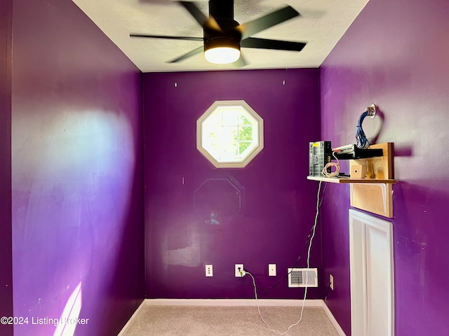 misc room with ceiling fan, carpet flooring, and a textured ceiling