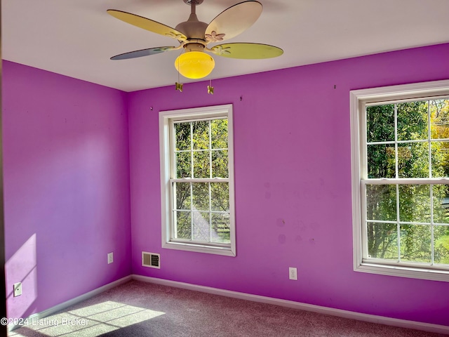 carpeted spare room with ceiling fan