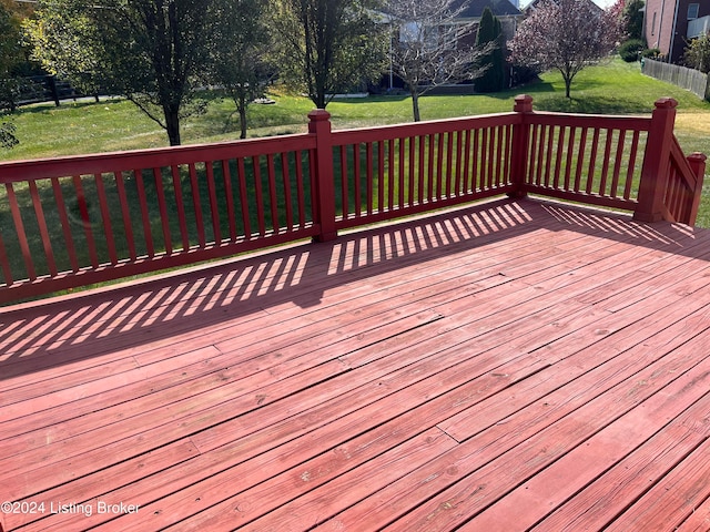 wooden terrace featuring a lawn