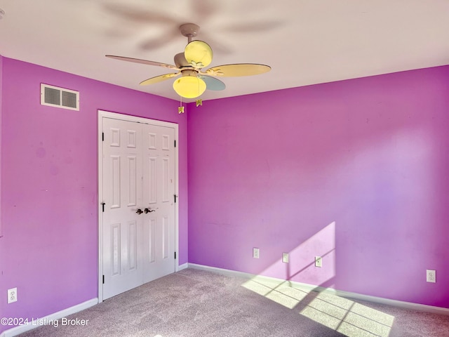 unfurnished bedroom with carpet floors, a closet, and ceiling fan