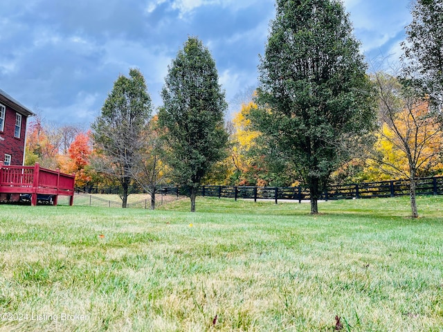 view of yard with a wooden deck and a rural view