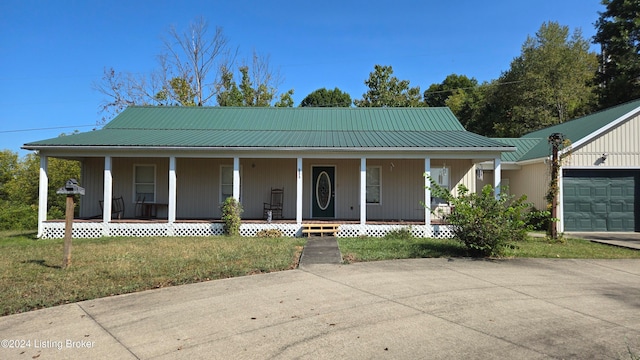 country-style home with a porch, a front lawn, and a garage