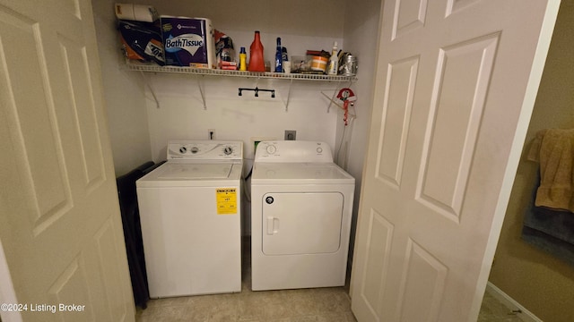 laundry room featuring washing machine and clothes dryer and light tile patterned floors