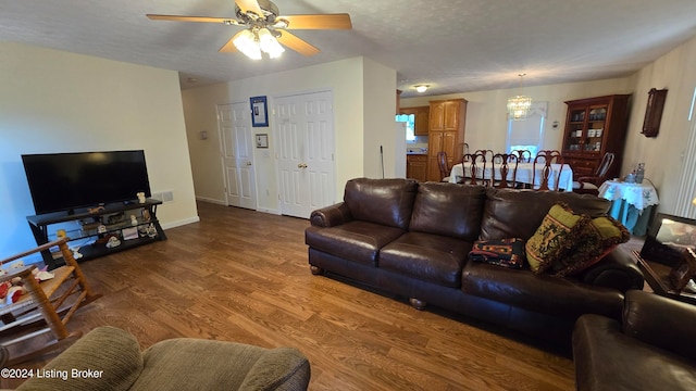 living room featuring hardwood / wood-style floors, a textured ceiling, and ceiling fan with notable chandelier