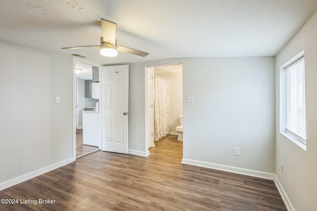 spare room with a textured ceiling, wood-type flooring, and ceiling fan