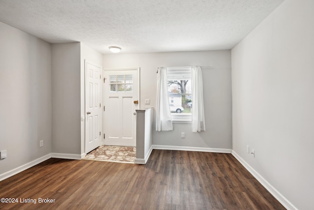 entryway with dark wood-type flooring and a textured ceiling