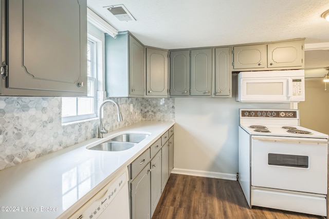 kitchen with white appliances, sink, a healthy amount of sunlight, and dark hardwood / wood-style floors