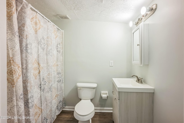 bathroom featuring hardwood / wood-style flooring, a shower with curtain, a textured ceiling, vanity, and toilet