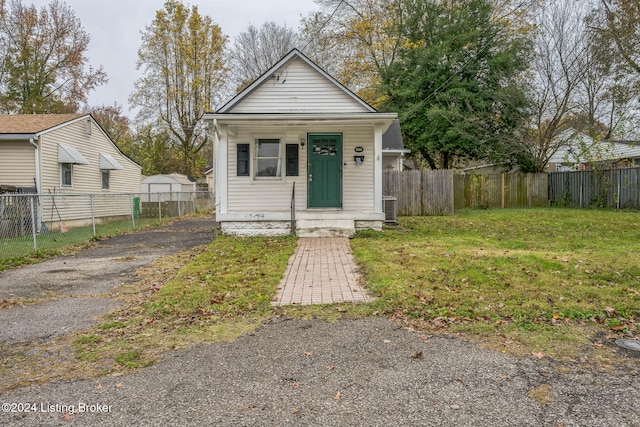 bungalow featuring cooling unit and a front lawn