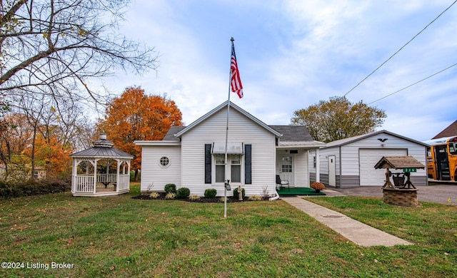 rear view of house with a gazebo, an outbuilding, a yard, and a garage