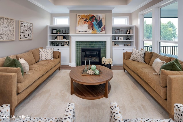 living room with light hardwood / wood-style flooring, a healthy amount of sunlight, a fireplace, and crown molding