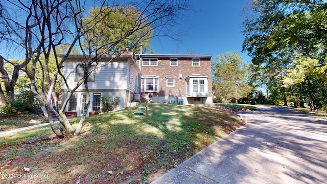 view of front of house with a front yard and brick siding