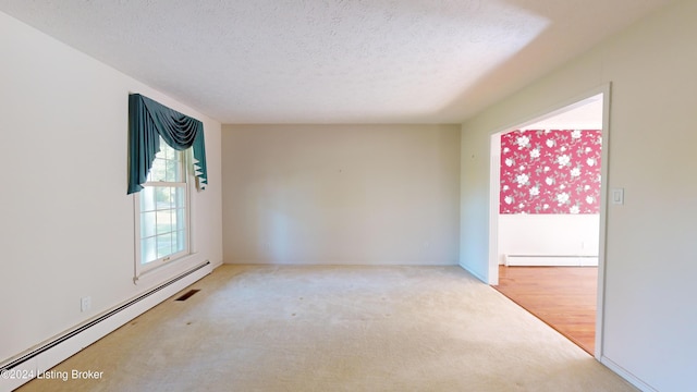 unfurnished room with baseboard heating, a textured ceiling, carpet, and a baseboard radiator