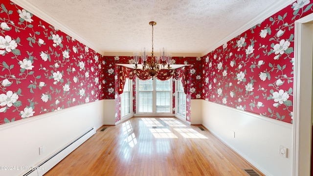 unfurnished dining area featuring a wainscoted wall, wallpapered walls, wood-type flooring, a textured ceiling, and baseboard heating