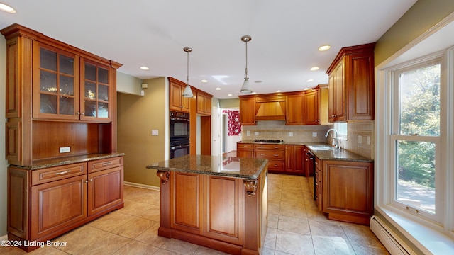 kitchen with black appliances, a sink, backsplash, a baseboard radiator, and custom exhaust hood