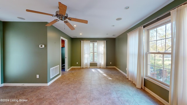 empty room with light tile patterned floors, visible vents, recessed lighting, and baseboards