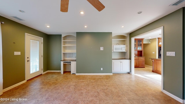 unfurnished room featuring visible vents, baseboards, and built in features