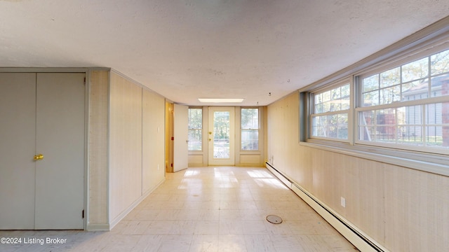 interior space with light floors and baseboard heating