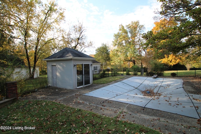 view of pool featuring a fenced in pool, a fenced backyard, a diving board, an outdoor structure, and a patio area