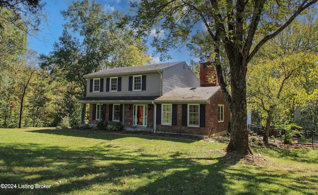 view of front facade featuring a front lawn, fence, brick siding, and a chimney