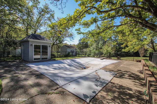 view of pool featuring an outdoor structure, a fenced in pool, a patio area, and fence